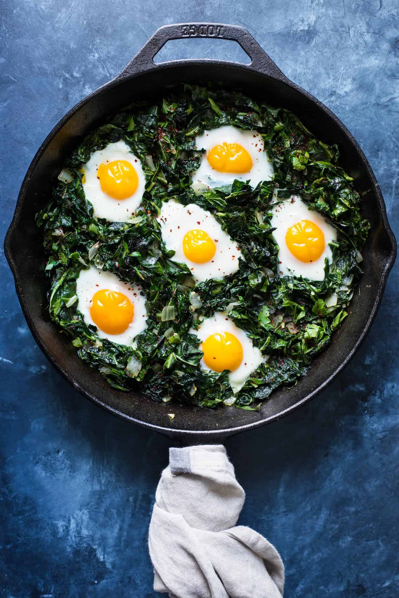 Green Shakshuka - a healthy breakfast dish filled with kale, collard greens and sunny side up eggs. An easy gluten-free meal!