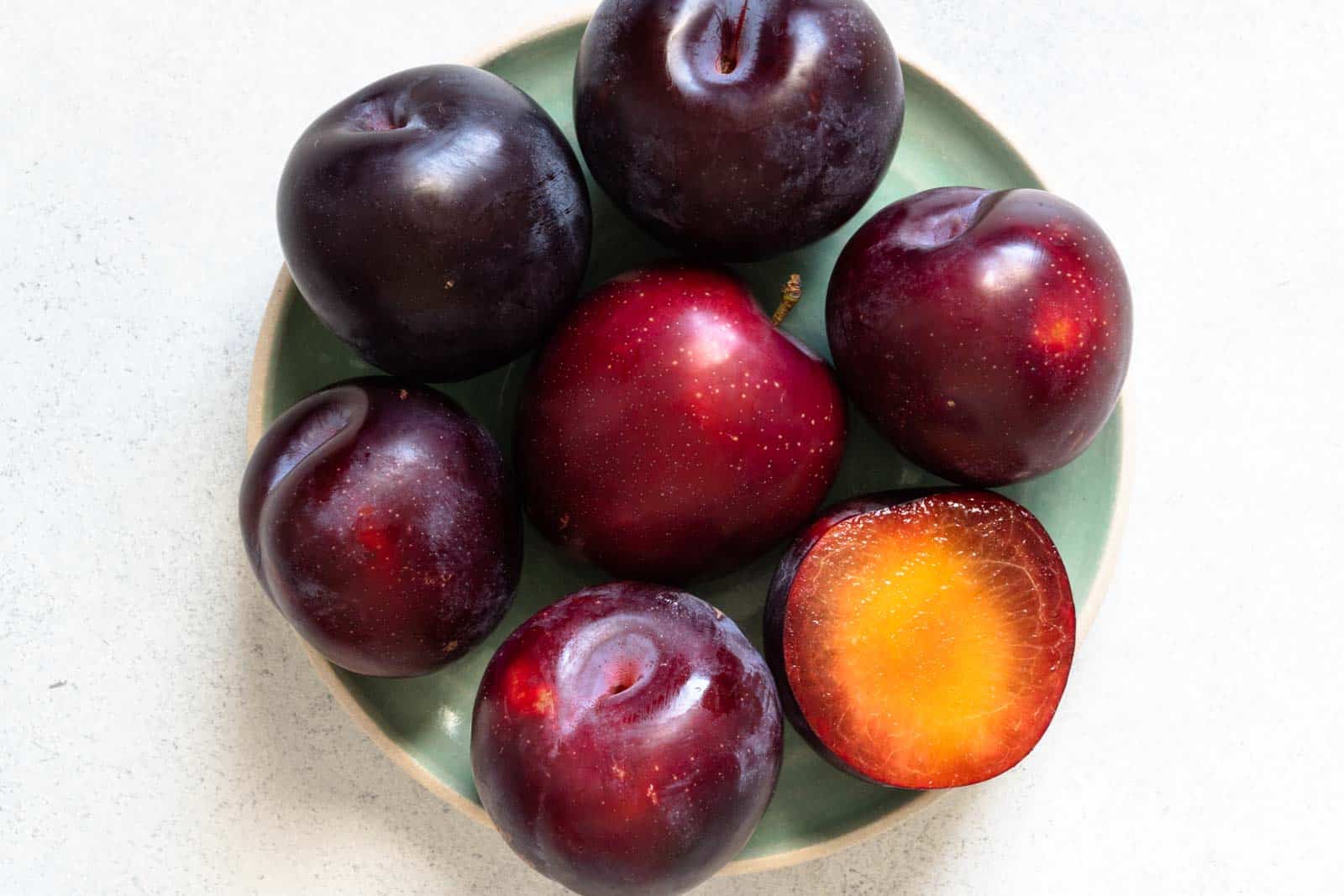 Plums on a plate for July produce guide